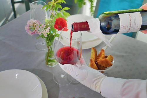 
a woman pouring a glass of wine into a vase at Hotel Modo in Pula
