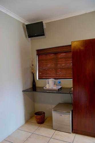 a kitchen with a counter and a window with a shelf at Tambati Overnight and Conference Center in Polokwane