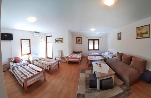 een grote woonkamer met banken en tafels bij Apartmani S.KILAĆI in Blagaj