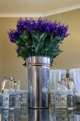 a vase filled with purple flowers sitting on a table at Tambati Overnight and Conference Center in Polokwane