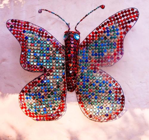 a mosaic butterfly ornament hanging on a wall at Butterfly Apartments in Livingstone
