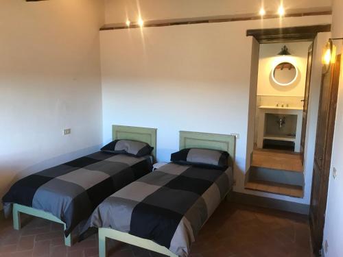 two beds sitting next to each other in a room at Casa Colle Petroso in Radda in Chianti