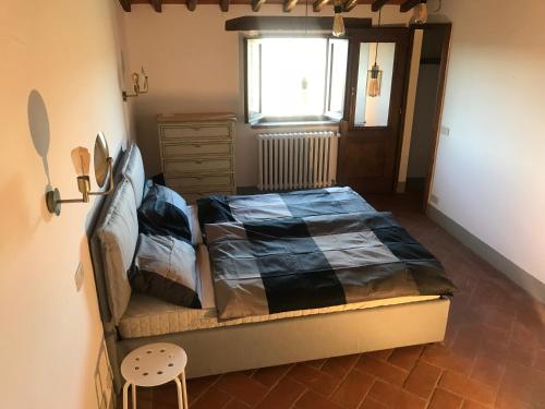 a bedroom with a bed and a window at Casa Colle Petroso in Radda in Chianti