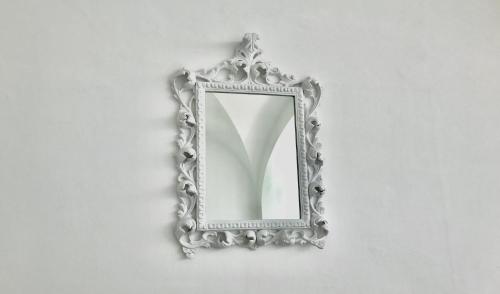 a silver mirror hanging on a white wall at Villa l'Approdo in Anacapri