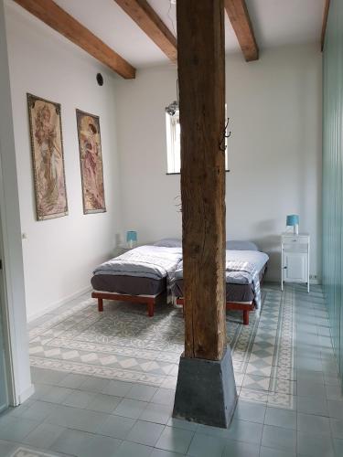 a room with two beds and a pole in it at Het Pakhuis Schiedam in Schiedam