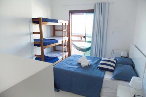a small bedroom with a bunk bed and a balcony at Enseada Hostel in Arraial do Cabo