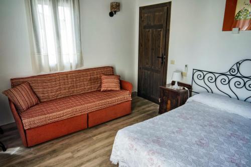 a living room with a couch and a bed at Casa del Hortelano in Chinchón