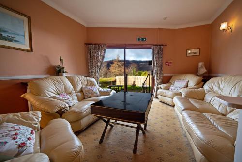 a living room with couches and a coffee table at The Rowan Tree Country Hotel in Aviemore