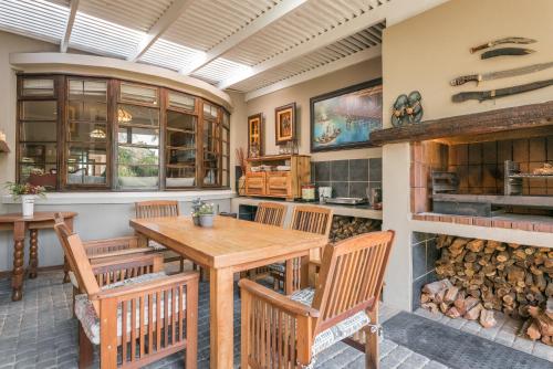 a dining room with a table and chairs and a fireplace at Caledon 23 Country House in George