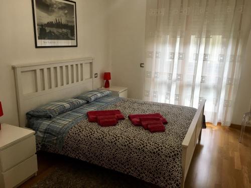 1 dormitorio con 1 cama con 2 toallas rojas en La Casa di Manolo en Bolonia