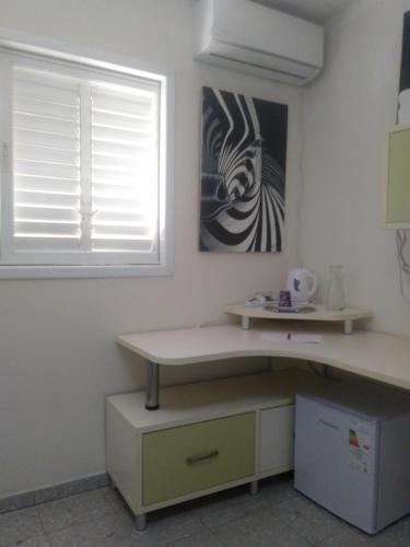 a room with a desk and a window and a table at Namaste in Tel Aviv
