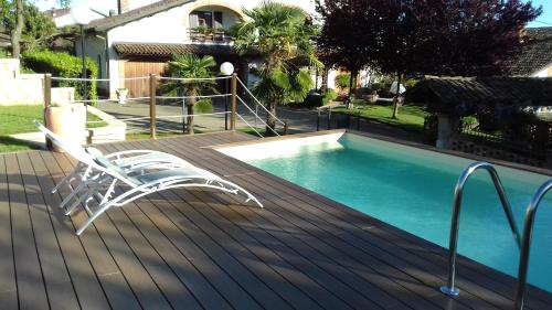 a white chair sitting on a deck next to a swimming pool at Bed And Breakfast Olimpia in San Salvatore Monferrato
