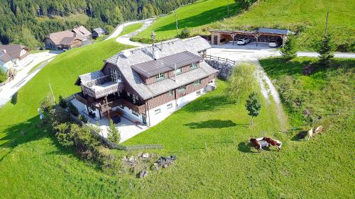 an aerial view of a large house in a field at Sonnenalm Mountain Lodge in Gröbming