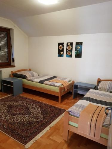 a room with two beds and a rug at Visoko Homestay in Visoko