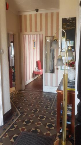 a room with a lobby with a desk and a table at Arman Lodge House in Peterborough