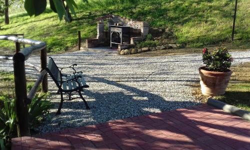 a bench sitting in the middle of a gravel road at Bed And Breakfast Olimpia in San Salvatore Monferrato