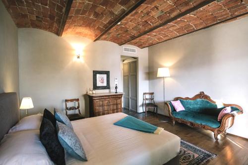 a bedroom with a bed and a couch in a room at MiaClara Relais in Alba