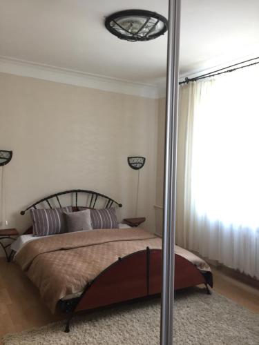a bedroom with a bed and a large window at Old Town apartament in Šiauliai