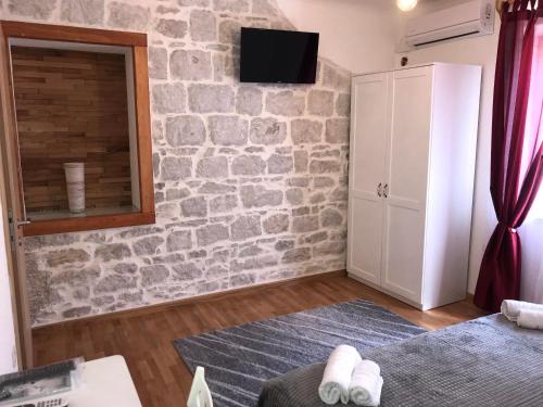 sala de estar con pared de piedra en Studio Apartment Sabljic, en Kaštela