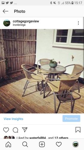 a photograph of a table and chairs in a room at Gorgeview Cottage in Ironbridge