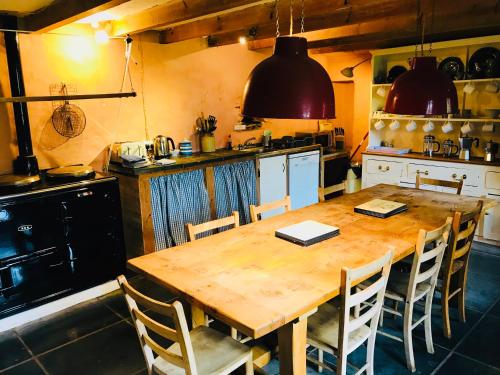 a kitchen with a large wooden table and chairs at The Barn, Higher Boden, Manaccan, Helston, Cornwall in Helston