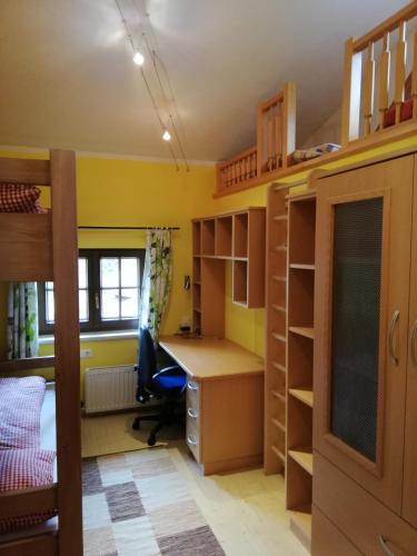 a bedroom with a desk and bunk beds at Holzfällerhaus Melkstatt in Auffach
