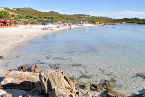 a beach with rocks and people in the water at VILLA ARANZOS in Golfo Aranci