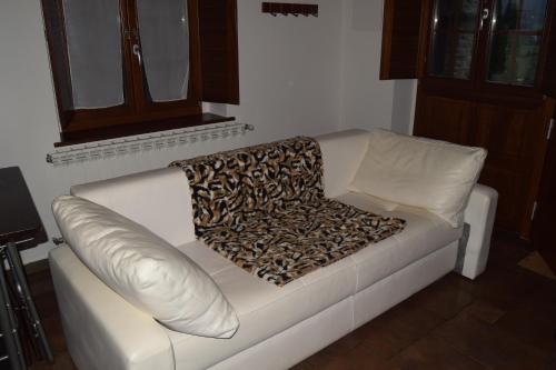 Un sofá blanco con una manta de leopardo. en Alborada del Eo, en Vegadeo