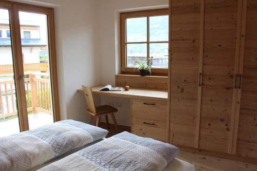 a bedroom with a desk and a bed and a window at Eco Bnb & Apartments Bründlerhof in Marlengo