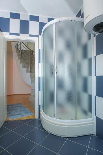 a glass shower in a room with a staircase at SENITA's Rooms & Apartments in Nin