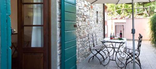 a patio with a table and chairs and an umbrella at Borgo I Vicelli Adults Only Relais in Bagno a Ripoli