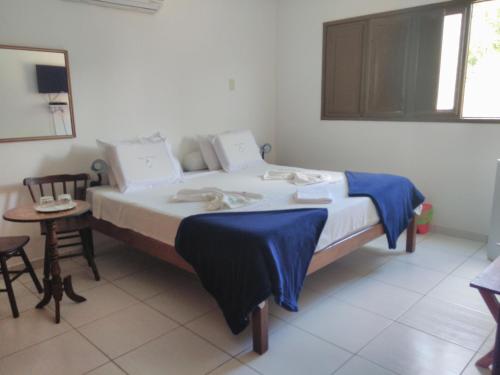 a bedroom with a bed with a blue blanket on it at Casa Schneider in Gravatá