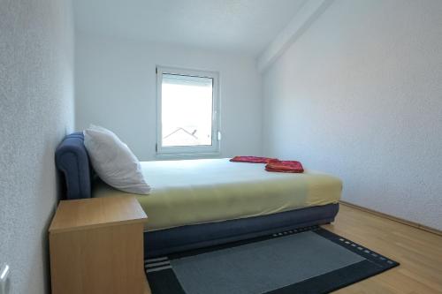 a small bed in a room with a window at SENITA's Rooms & Apartments in Nin