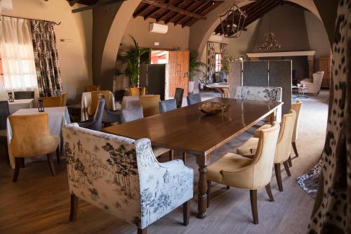 a dining room with a wooden table and chairs at Hotel Rural Las Tejuelas in Valdecaballeros