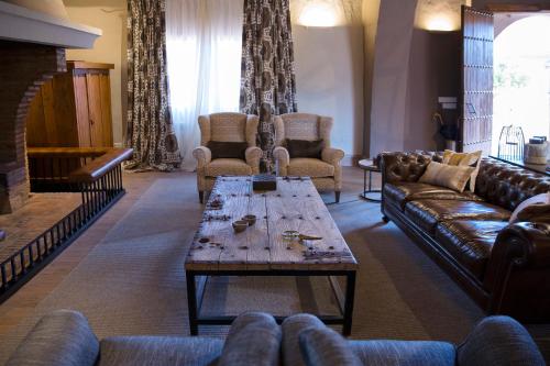 a living room with couches and a coffee table at Hotel Rural Las Tejuelas in Valdecaballeros