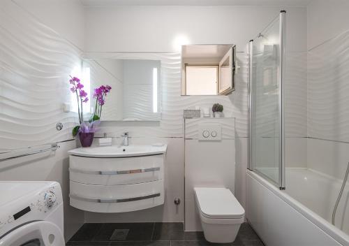 a white bathroom with a toilet sink and a shower at Adriatic Dream Apartments in Dubrovnik