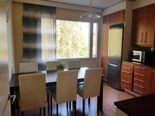 a kitchen with a dining room table with chairs and a window at Home Away Holiday in Kuopio