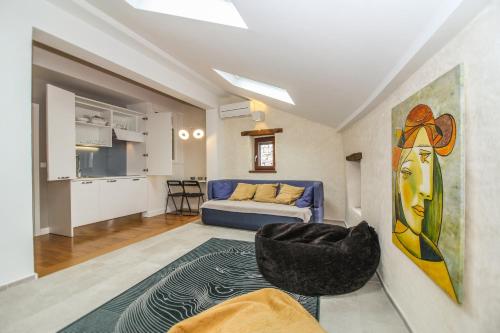 a living room with a blue couch and a kitchen at Villa Castel in Bale