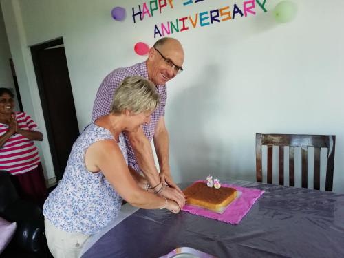 a man and a woman cutting a birthday cake at Dreamscape home stay in Kandy
