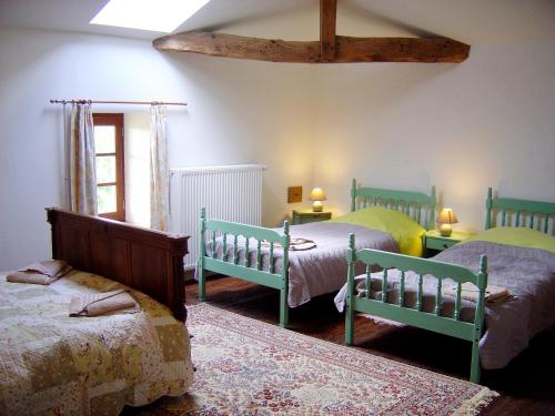 um quarto com 3 camas e uma janela em Les Trois Chenes em Videix