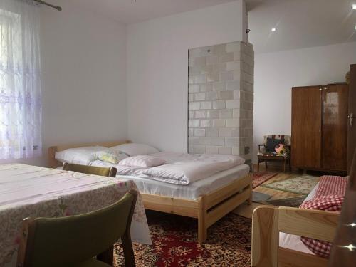 a bedroom with two beds and a fireplace at Zagroda u Leny - Dom na wyłączność in Czyże