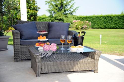 a wicker chair with a table with wine glasses and fruit at B&B La Magia dei Sogni Relais in Verona