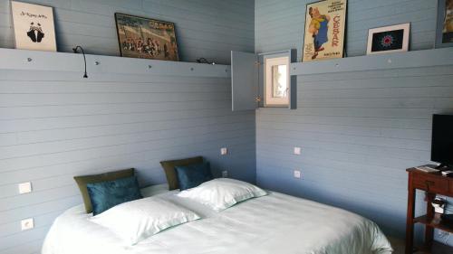 1 dormitorio con 1 cama blanca y paredes azules en Sous les chênes, en Provence, en Eyragues