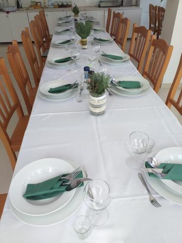 a long table with plates and wine glasses on it at Villa Rigo Panzió in Verpelét