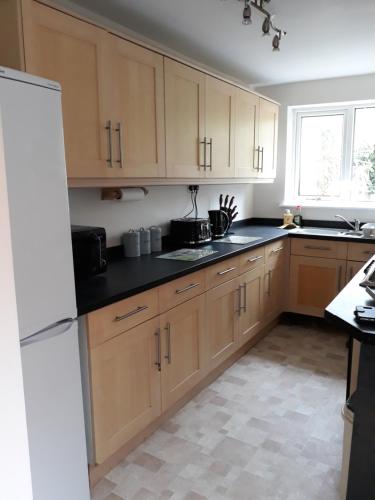 a kitchen with wooden cabinets and a white refrigerator at Lincoln lets 23 in Lincoln