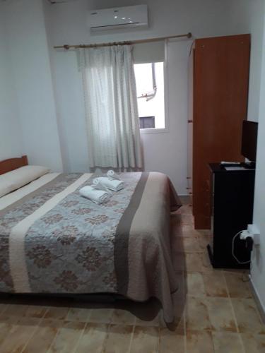 1 dormitorio con 1 cama con 2 toallas en Hostal Virgen Del Pilar, en Baza