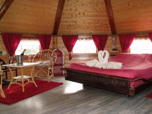 a bedroom with a large bed and a table at Le Domaine du Châtelet in Ferdrupt