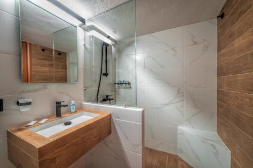 uma casa de banho branca com um lavatório e um chuveiro em LP Luxury Citycenter Studio em Xanthi