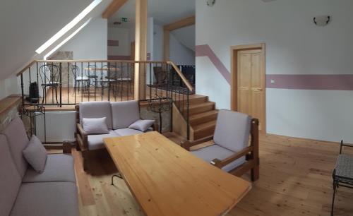 a living room with a table and chairs and stairs at Ubytování pod rozhlednou in Skuteč