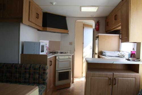 a small kitchen with a stove and a microwave at lathuillere in La Motte-Saint-Jean